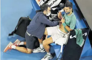  ?? // AFP ?? Djokovic, siendo atendido en su último partido ante Taylor Fritz por unas molestias en la zona abdominal