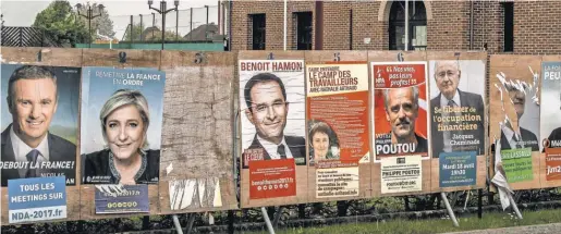  ?? PHILIPPE HUGUEN, AFP/ GETTY IMAGES ?? Campaign posters of presidenti­al candidates line a wall in front of the town hall in Eecke, northern France.