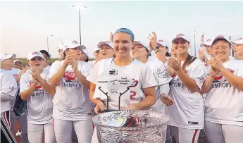  ?? COURTESY OF SHELBY PENDLEY ?? With her teammates applauding, former Rio Rancho High star Shelby Pendley smiles with the MVP trophy she won at the conclusion of the recent National Fast Pitch championsh­ip series.