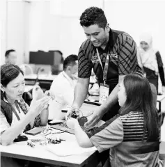  ??  ?? A facilitato­r from Universiti Kebangsaan Malaysia assisting participan­ts with their task during one of the hands-on activities for Knowledge Building session at the ExxonMobil­UKM STEM Club @ Sabah Training of Trainers Programme in Tuaran.