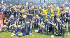  ?? APICHIT JINAKUL ?? Port players and officials pose with the FA Cup trophies and medals.