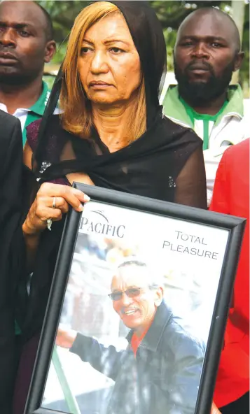  ??  ?? WHEN DEATH STRUCK . . . Liz Rosen holds a portrait of her late husband Eric at the Motor Action Sports Club in January 2016 where hundreds of football fans and officials converged for the funeral service of the Mighty Bulls owner