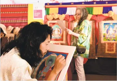  ?? NEW MEXICAN FILE PHOTO ?? Kalsang Tashi of Tibet paints as the early-bird crowd arrives at the 13th annual Folk Art Market on Museum Hill in 2016.