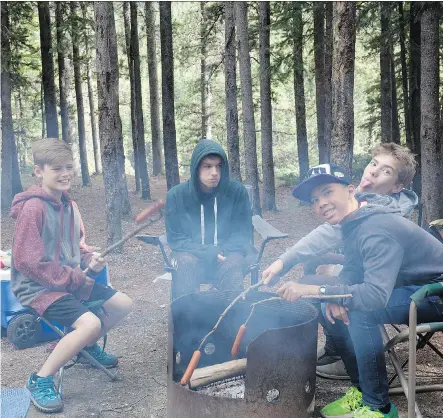  ?? PHOTOS: ANDREW PENNER ?? The Penner boys and Evan have fun around the fire during the 23-hour annual camping trip.