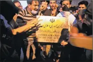  ?? AP/NABIL AL-JURANI ?? Protesters hold a sign belonging to the Iranian consulate building before storming and burning it Friday in Basra.