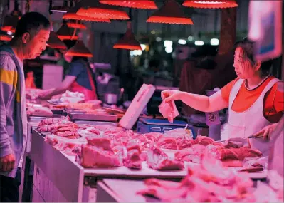  ??  ?? Por las nubes Un cliente compra carne en una parada en Shenyang, en el noroeste de China.