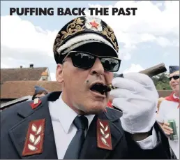  ??  ?? A MAN dressed as the late leader of socialist Yugoslavia Josip Broz Tito, smokes his cigar in Kumrovec village, 75km north-west of Zagreb yesterday.thousands of people from the formeryugo­slavia gathered yesterday in the Croatian village, the birthplace...