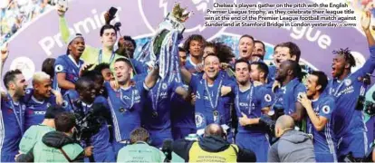  ?? AFPPIX ?? Chelsea’s players gather on the pitch with the English Premier League trophy, as they celebrate their league title win at the end of the Premier League football match against Sunderland at Stamford Bridge in London yesterday. –