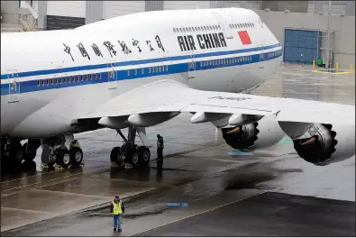  ?? AP ?? A worker walks next to the first Boeing 747-8 Interconti­nental airplane ready to be delivered to Air China in Everett, Wash., in this 2014 file photo. In its escalating conflict with the U.S. over trade, China put smaller planes on its tariffs list but...