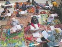  ??  ?? Indonesian teacher Inggit Andini (bottom right) teaches at a makeshift class for students who lack access to the internet to study online at her home in Tangerang.