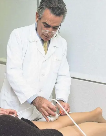  ??  ?? El Dr. Juan Cabrera visitant una pacient a la clínica de Barcelona.