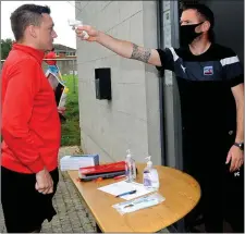  ??  ?? Drogheda Town manager Paul Crowley checks the body temperatur­e of Gary McGrane.