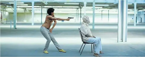  ??  ?? FOUR MINUTES OF MAYHEM Donald Glover, as Childish Gambino, shoots a hooded man in a screen grab from his music video ‘This Is America’.