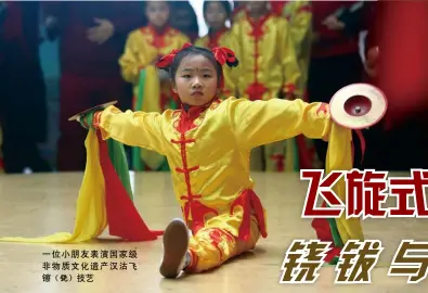  ??  ?? 一位小朋友表演国家级­非物质文化遗产汉沽飞­镲（铙）技艺