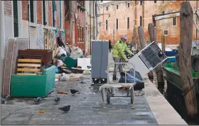  ?? ANSA via AP/ANDREA MEROLA ?? People remove damaged items Monday from an alley in Venice, northern Italy.