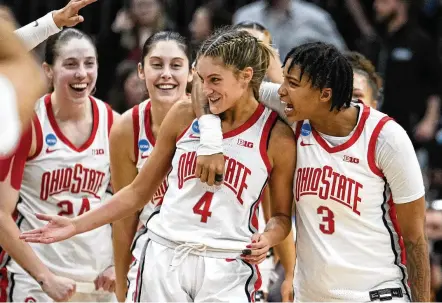  ?? MICHAEL CONROY / ASSOCIATED PRESS ?? Ohio State guard Jacy Sheldon (4) is hugged by guard Hevynne Bristow after Ohio State defeated North Carolina in a second-round NCAA Tournament game in Columbus on Monday. Sheldon’s basket with 1.8 seconds remaining gave the Buckeyes a 71-69 victory, sending them into the Sweet 16. She finished with 16 points on the day.