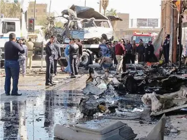  ?? — AFP ?? Terror attack: Iraqis inspecting the damage of a bombing in the central city of Hilla yesterday.