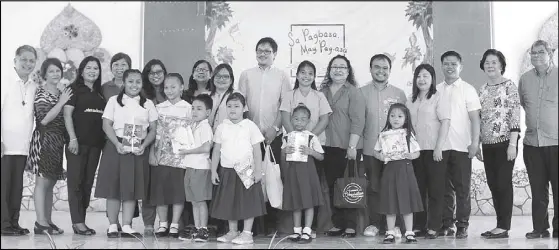  ??  ?? Pupils and teachers of Aurora A. Quezon Elementary School in Malate, Manila accept storybook donations from ‘Sa Pagbasa, May
Pag-asa’ partner publishers during the turnover ceremony led by campaign co-convenors Philippine Business for Social Progress...