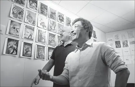  ?? Robert Gauthier Los Angeles Times ?? DC COMICS
chiefs Dan DiDio, left, and Jim Lee review covers of upcoming special editions planned by the comic book company.