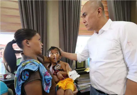  ?? -Chris Navarro ?? MCG CARES. Mabalacat City Mayor Cris Garbo comes to the aid of a sick child during a recent visit to the city hall. Garbo quickly shouldered the medical needs of the young patient.