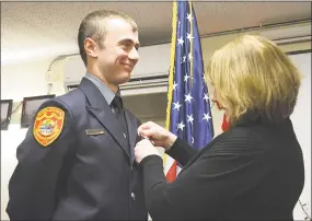  ?? Cassandra Day / Hearst Connecticu­t Media ?? Middletown firefighte­r Mary Andrew pins her son Owen during his swearing-in ceremony Monday.