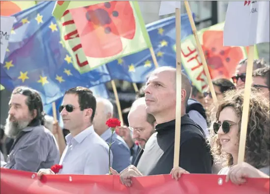  ?? Armando Franca Associated Press ?? YANIS VAROUFAKIS, center right, marches in a Lisbon parade in April. The former Greek finance minister’s new book explains the machinatio­ns of economies.