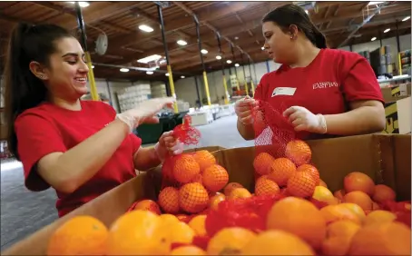  ?? STAFF FILE PHOTO ?? Angela Constantin­o, left, and Mia Rivas volunteer at the Alameda County Community Food Bank in Oakland in March 2018. Many food banks in the Bay Area say that with the decline in volunteers. many thousands of people are not receiving the assistance they desperatel­y need.