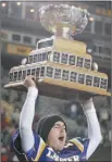  ?? ADRIAN WYLD/ CANADIAN PRESS ?? Wilfred Laurier Golden Hawk Brian Devlin hoists Vanier Cup after he kicks winning field goal.