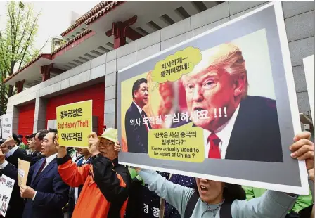  ??  ?? Raw nerves: South Korean historians and activists protesting outside the Chinese embassy in Seoul after Trump allegedly reiterated to Xi that the peninsula ‘used to be part of China’. — AFP