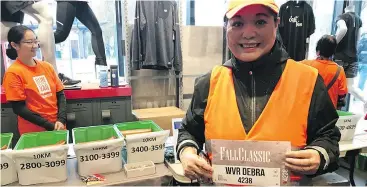  ?? GORD KURENOFF/POSTMEDIA ?? Debra Kato of the West Van Run Crew picked up her bib Saturday at Forerunner­s on Main Street ahead of today’s Fall Classic at UBC.