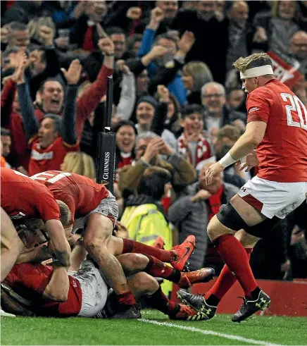  ?? AP ?? Wales winger Josh Adams, on ground, is congratula­ted by jubilant team-mates after scoring the match-clinching try in the 21-13 win over England.