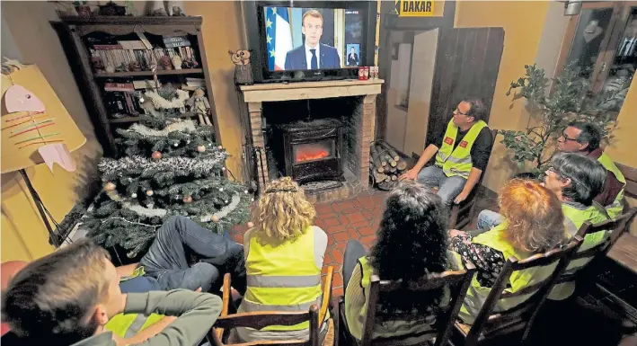  ?? REUTERS ?? Atentos. Un grupo de “Chalecos Amarillos” escucha anoche en Gaillon al presidente de Francia, Emmanuel Macron, durante su discurso de 13 minutos por televisión.