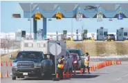  ?? THE CANADIAN PRESS/FILES ?? Provincial health department workers stop traffic that has crossed the Confederat­ion Bridge in Bordencarl­eton, P.E.I. The island province has largely avoided COVID outbreaks due to stringent border requiremen­ts.