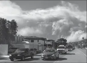  ?? GENARO MOLINA/LOS ANGELES TIMES ?? People evacuate Malibu against a backdrop of the Woolsey Fire on Friday.