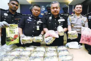  ??  ?? Roslee (second from right) and Indonesia police representa­tive Chaidar (right) showing the confiscate­d syabu and ecstasy pills during a press conference at Penang police contingent headquarte­rs yesterday.