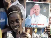  ?? PICTURE: REUTERS ?? SUCCESSION: A woman holds a picture displaying all the popes to have visited Uganda while waiting for Pope Francis to arrive in the capital Kampala, yesterday.