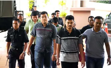  ??  ?? Muhmmad Rezal (front, second right), Muhamad Aminruddi (front, second left) Muhammad Nur Adnan (second left, back row) were charged at the Sessions Court in Kuantan. — Bernama photo