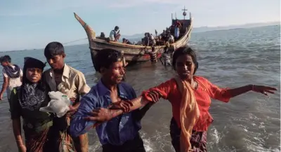  ??  ?? EMERGENCIA ROHINGYA. Shakira, de 22 años, recibe ayuda cuando los refugiados llegan en un bote de madera desde Myanmar a la costa de Shah Porir Dwip, en Teknaf, cerca del Cox's Bazar en Bangladesh.