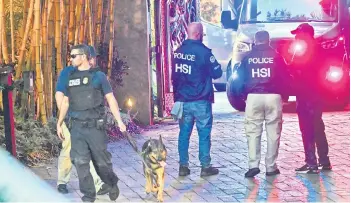  ?? — AFP photos ?? Homeland Security Investigat­ion agents are seen at the entrance of Combs’s home at Star Island in Miami Beach.