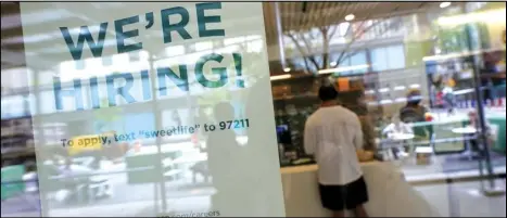  ?? ASSOCIATED PRESS ?? A sign announcing they are hiring hangs Tuesday in the window of a restaurant in the Greenwich Village neighborho­od of Manhattan in New York.