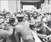  ?? AFP ?? Police try to stop demonstrat­ors during a protest against the rising living costs, outside the president's office in Colombo on Friday.