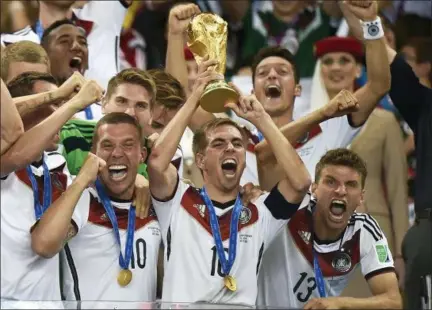  ?? MARTIN MEISSNER — THE ASSOCIATED PRESS FILE ?? Germany’s Philipp Lahm (16) raises trophy after the 2014 World Cup final soccer match between Germany and Argentina at the Maracana Stadium in Rio de Janeiro, Brazil.