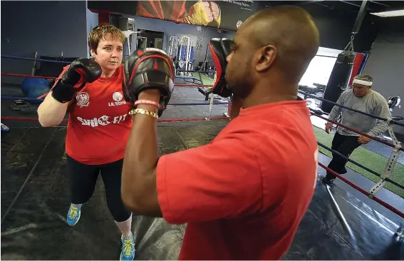  ?? Photograph­y David Bebee ?? Sandi Hall, webmaster at Waterloo Public Library, takes out her stress in training sessions with Kitchener boxer and gym owner Syd Vanderpool.