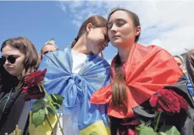  ?? NATACHA PISARENKO/AP ?? Women attend a memorial service of activist and soldier Roman Ratushnyi at Maidan square in Kyiv, Ukraine, on Saturday. Ratushnyi died in a battle near Izyum, where Russian and Ukrainian troops are fighting for control of the area.