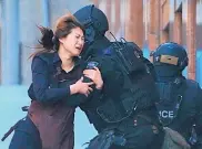  ?? ROB GRIFFITH/ASSOCIATED PRESS ?? A hostage runs to armed tactical response police officers for safety after she escaped from a cafe under siege in Sydney, Australia, in 2014.