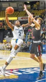  ?? STAFF PHOTO BY TIM BARBER ?? UTC’s Jerry Johnson Jr. drives to the basket against VMI’s Garrett Gilkeson in the first half Sunday at McKenzie Arena. The Mocs won 83-65,