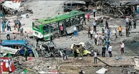  ?? SANA ?? Syrians inspect the damage from a car bombing Monday in Jableh, the site of three additional explosions. Shortly afterward, three explosions rocked Tartus.