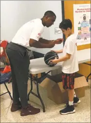  ?? Jeff Jacobs/Hearst Connecticu­t Media Group ?? Former UConn coach Kevin Ollie signs an autograph during Sunday’s charity event.