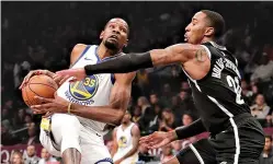  ?? AP Photo/Frank Franklin II ?? ■ Brooklyn Nets’ Caris LeVert (22) defends against Golden State Warriors’ Kevin Durant during the first half Oct. 28, 2018, in New York.