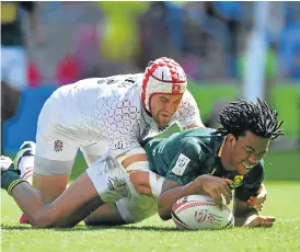  ?? /AFP ?? Try time: Stedman Gans goes over with Phil Burgess on his back in the Blitzboks’ semifinal win over England. Gans scored against Fiji in the final though it was not enough to avoid defeat.